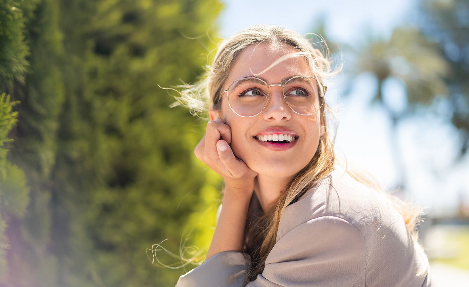 Eine blonde Frau hat ein dünnes Metall Brillengestell auf.